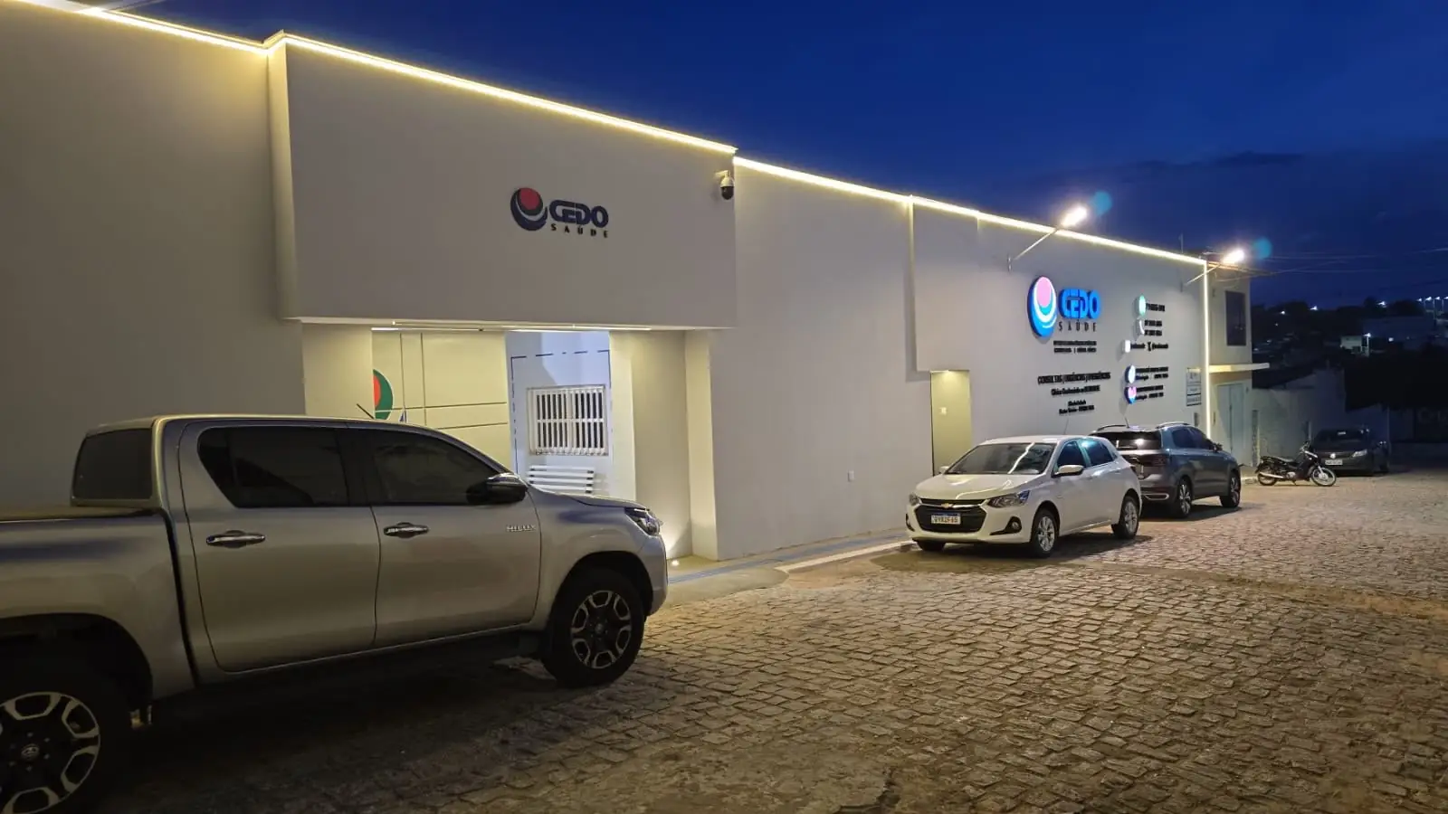 Fachada iluminada da clínica CEDO Saúde em Araripina, à noite